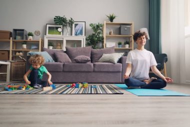 a woman and a child sitting on a rug in a living room